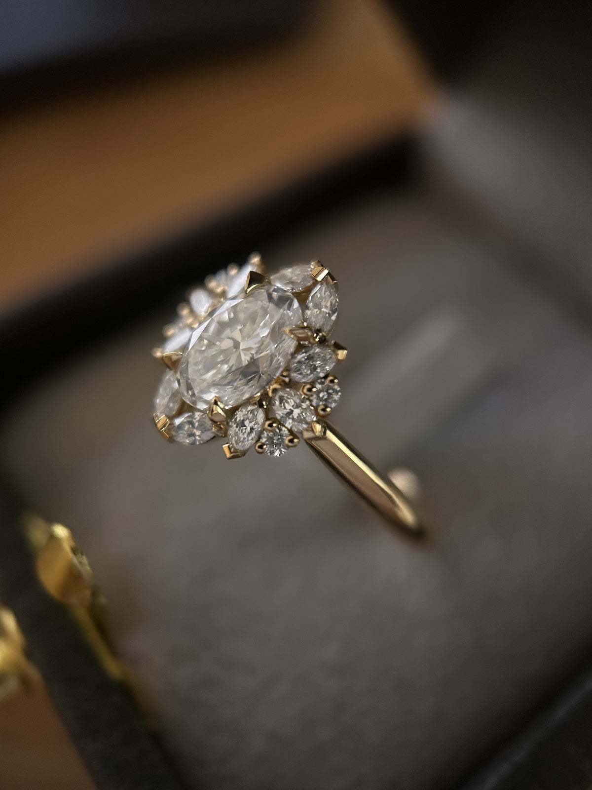 Bague de fiançailles en or jaune avec diamant central taille ovale entouré de diamants