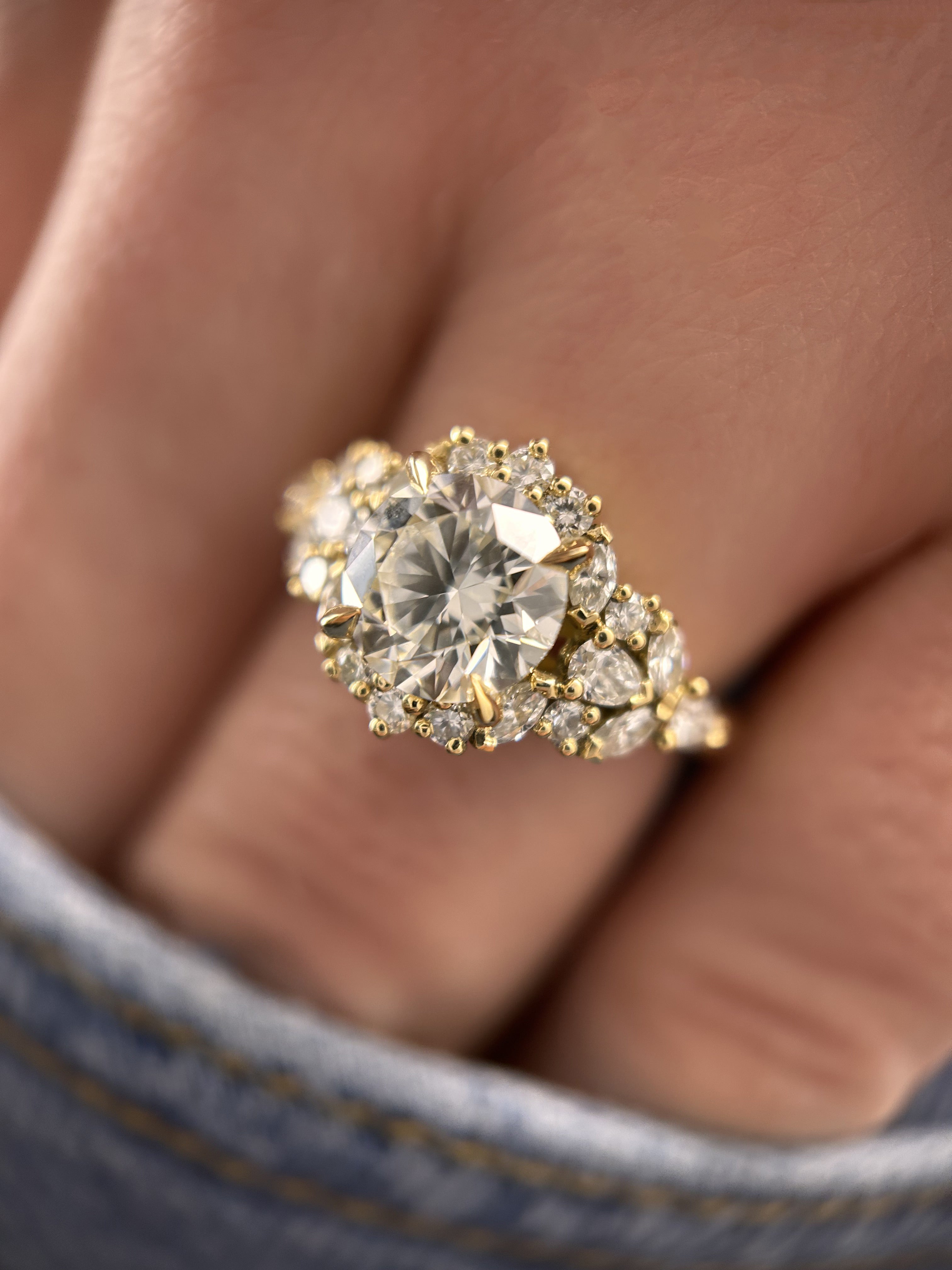 bague de fiançailles diamant entourage or jaune portée sur doigt