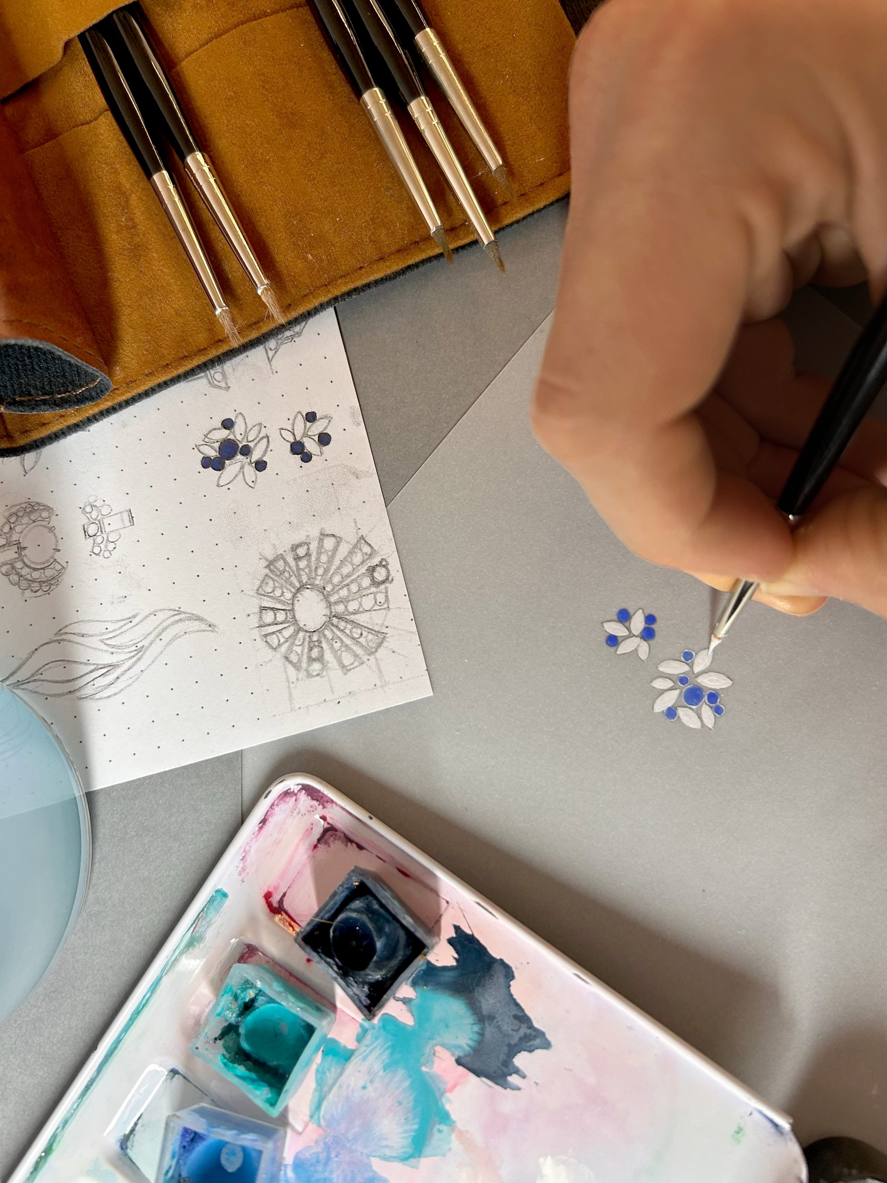 dessins gouachés et recherche croquis pour une bague entre les doigts diamants et saphirs