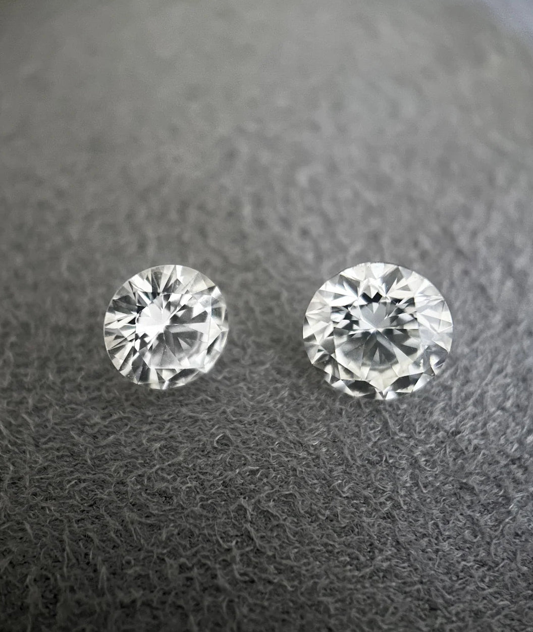Deux diamants taille brillant observés pour la création d’une bague de fiançailles sur mesure dans un atelier de joaillerie