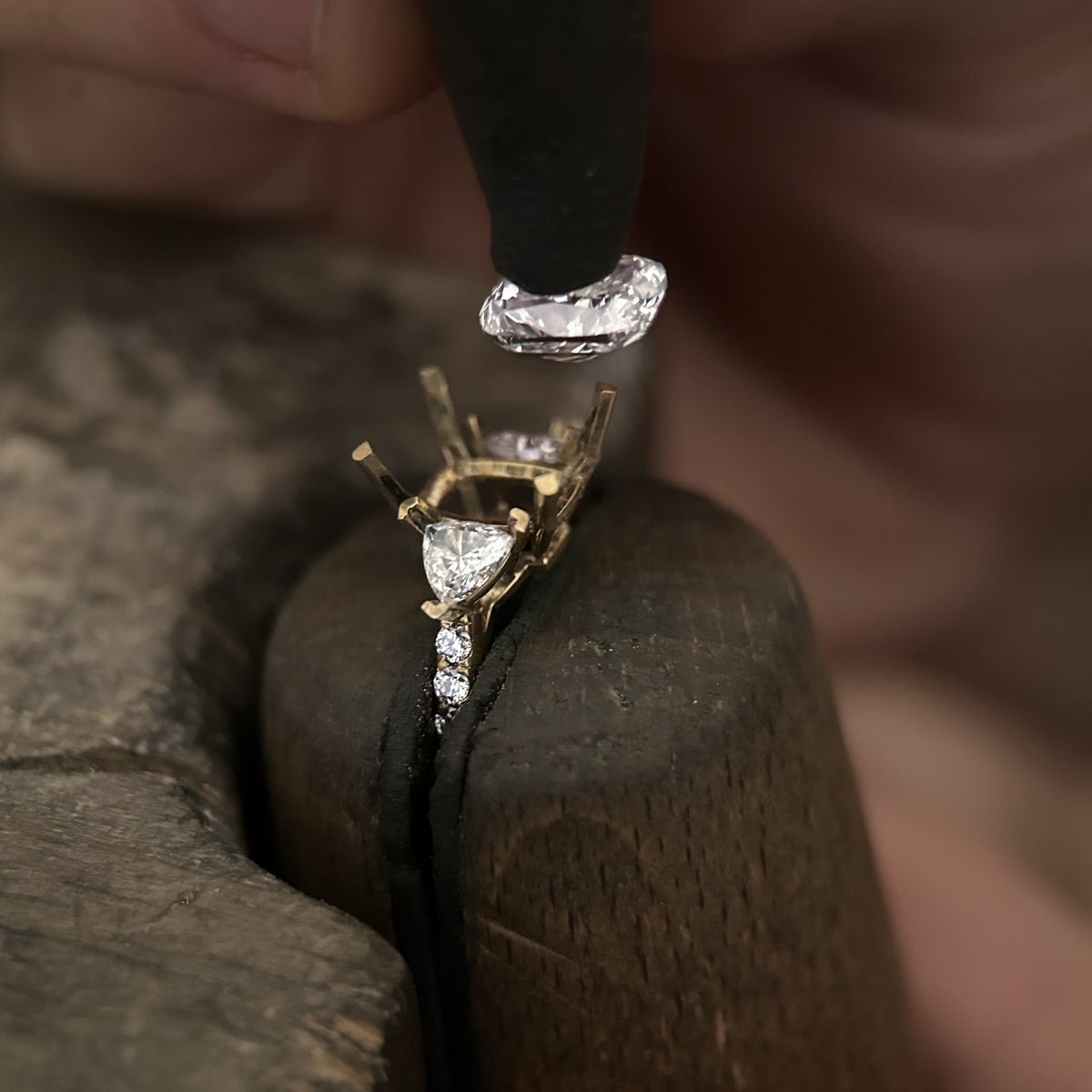 Sertissage des diamants sur une bague de fiançailles en or jaune